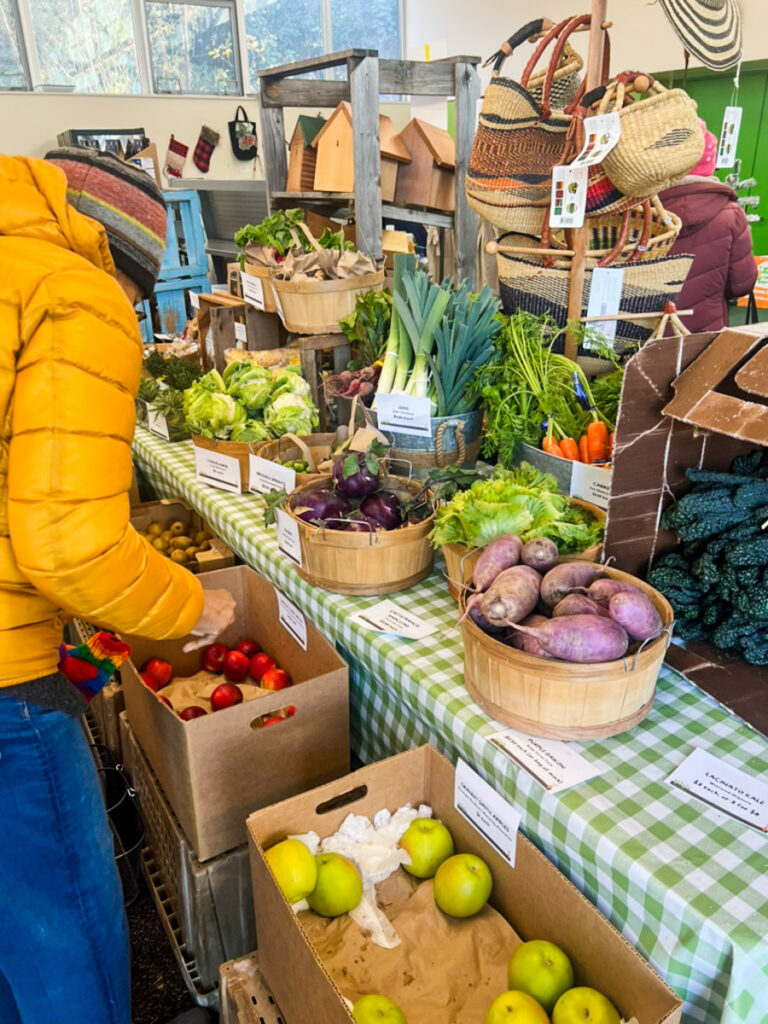 A shopper browses through produce in baskets on a table
