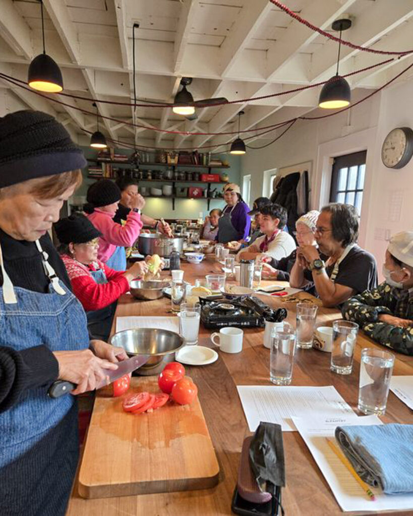 Senior adults learning cooking skills at indoor kitchen class